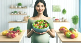 Беременная женщина с большой миской здорового салата на кухне с фруктами.